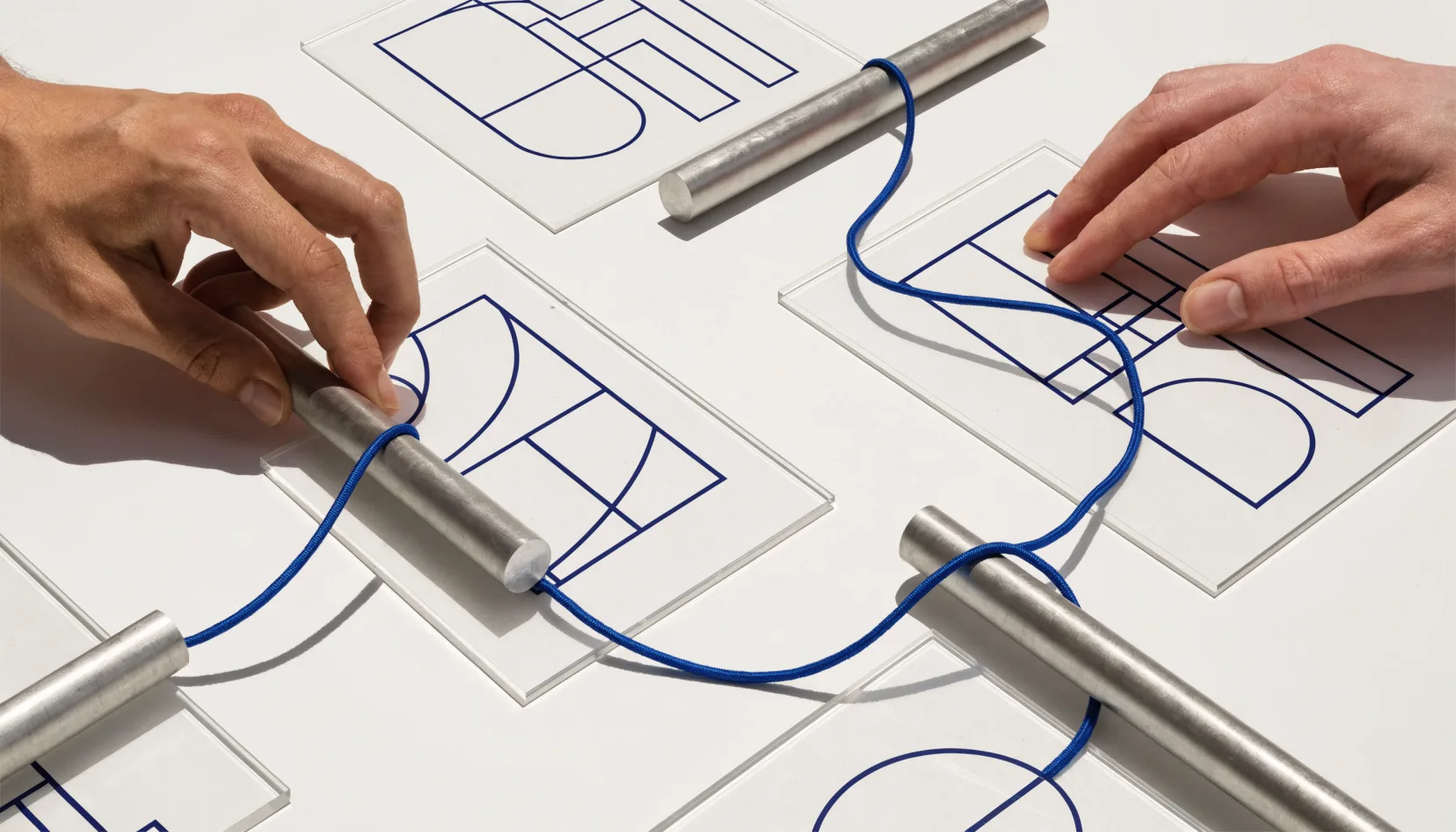 Hands connecting transparent diagrams with a single blue line.